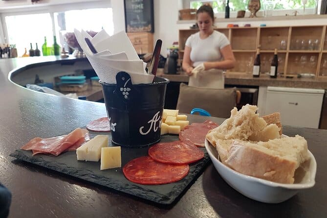 Woman preparing Portuguese wine, cheese, meats and bread 