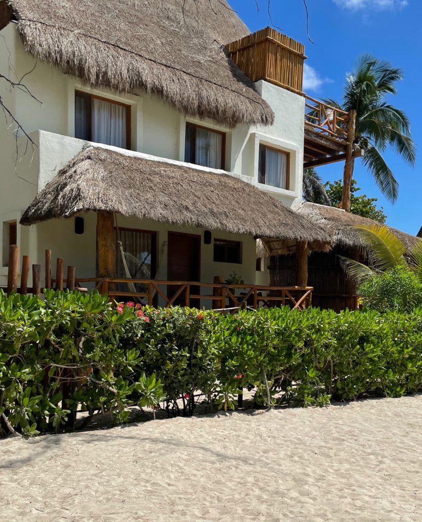 beach house with classic palapa sides on the roof by a beach in Playa Del Carmen