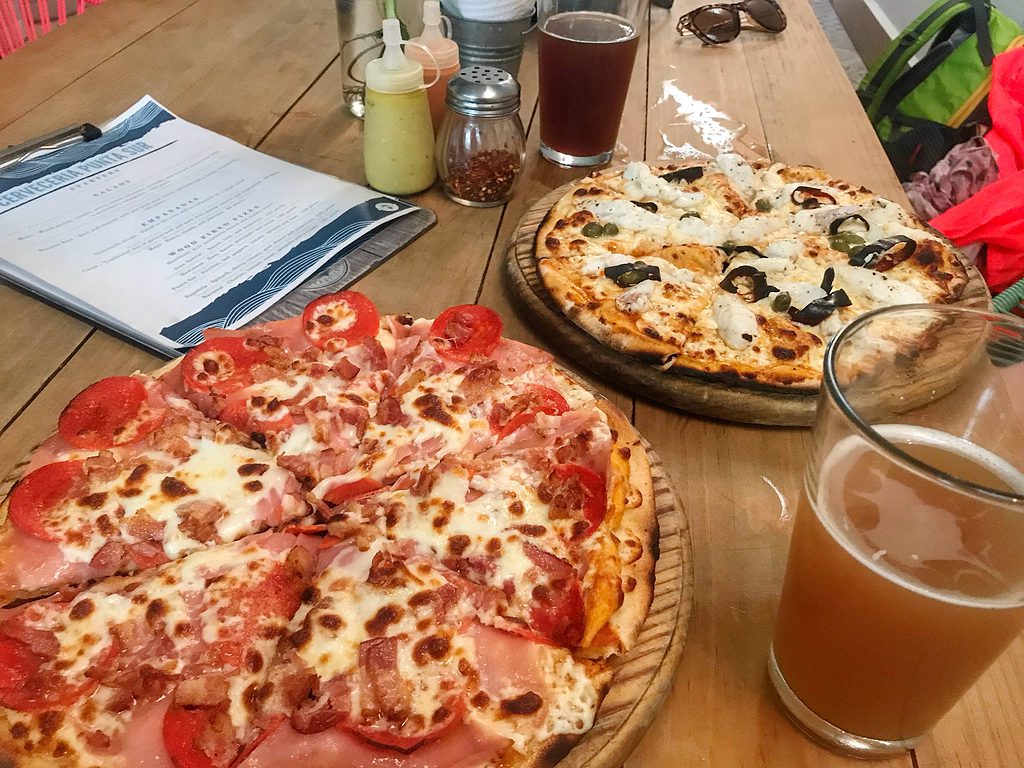 two wood fired pizzas and freshly brewed beers from cerveceria punta sur restaurant in cozumel mexico