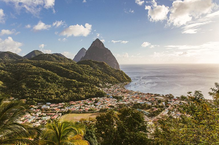 stunning sunset in the famous Caribbean island St Lucia showing stunning greenery alongside homes with clear skies and a calm sea