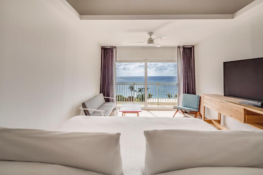the view inside of a room at fiest americana resorts in cozumel, you can see the bright blue ocean and palm trees from the room