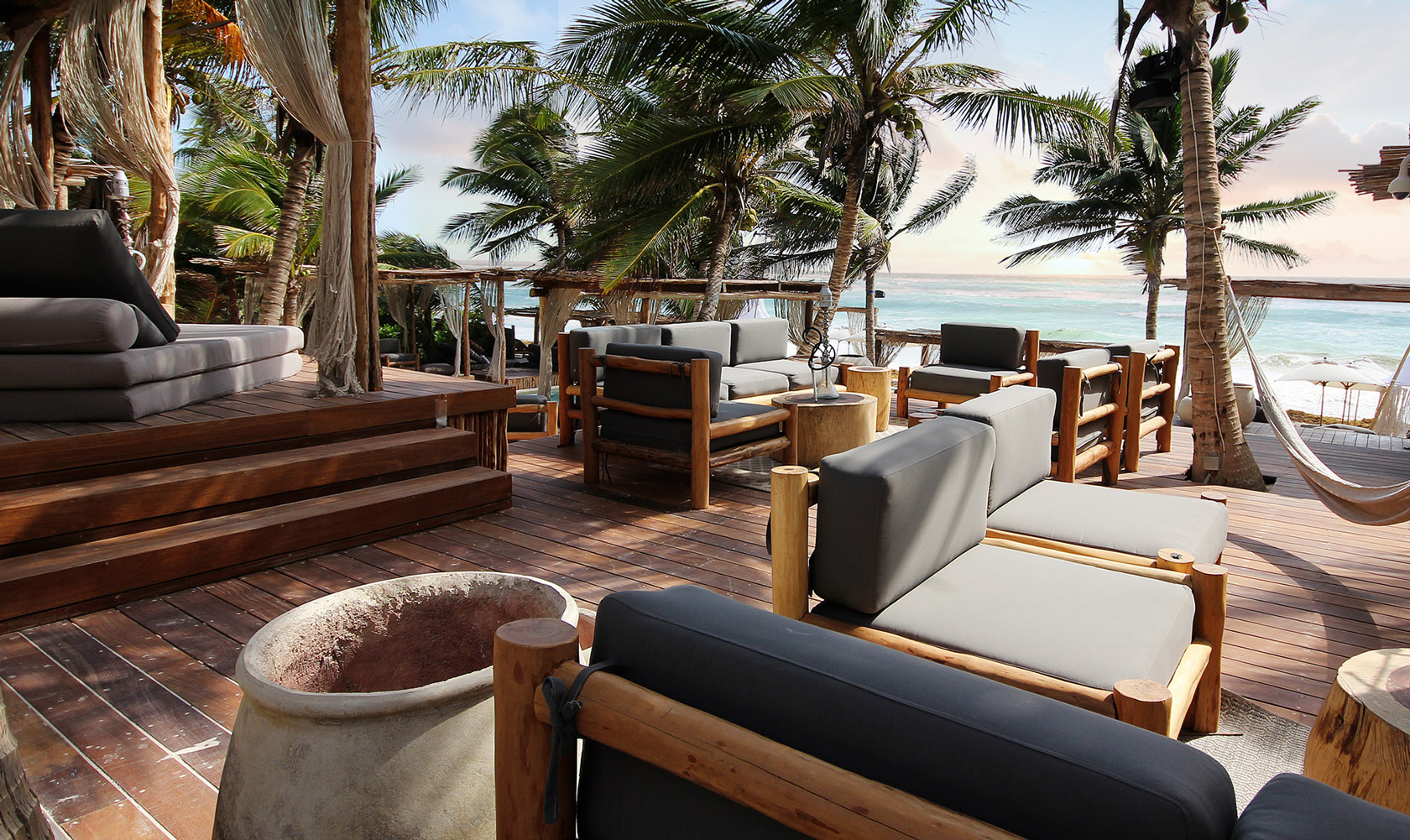 the private beach area with several lounge sofas to relax by the sea at taboo one of the best tulum beach clubs