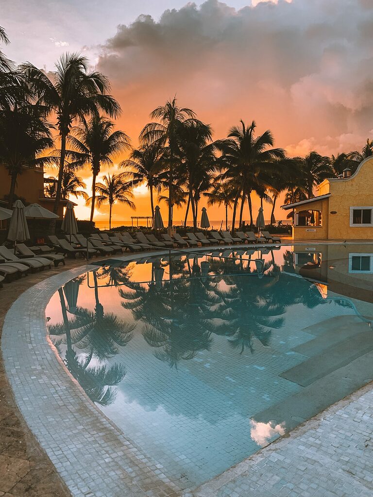 sunset in the sky with various shades of pink by the pool in Cancun, Mexico