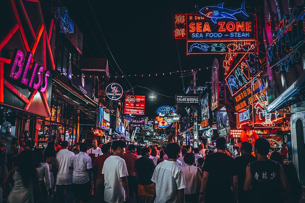 a crowd of tourists walking the nightlife streets of Pattaya City, Thailand