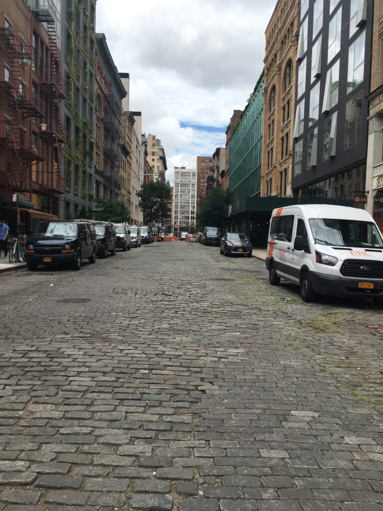 cobblestone street full of cars parked in SOHO, New York City 