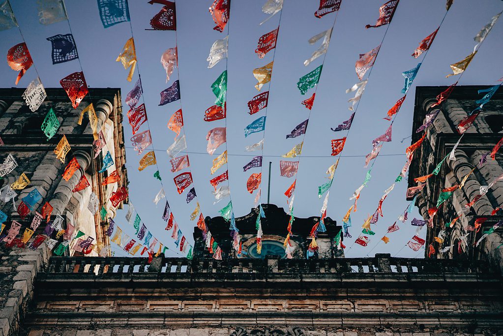 various streams of bright colours decorations in the sky attached to a building in Valladolid, Mexico
