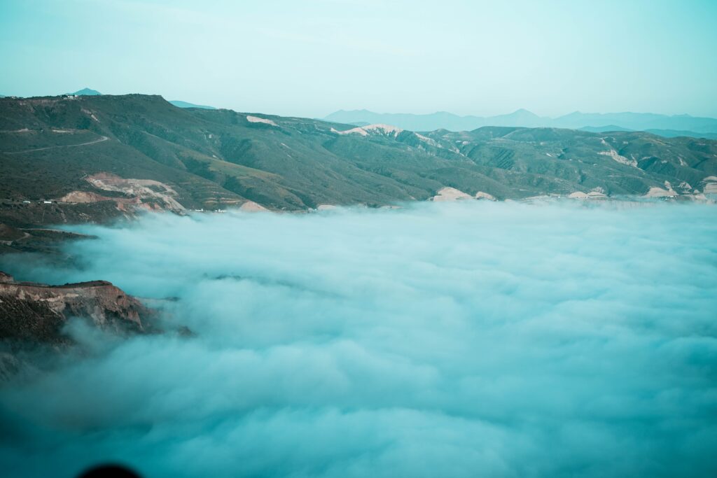 views of from a high mountain top showing clouds amongst the city of Ensenada 