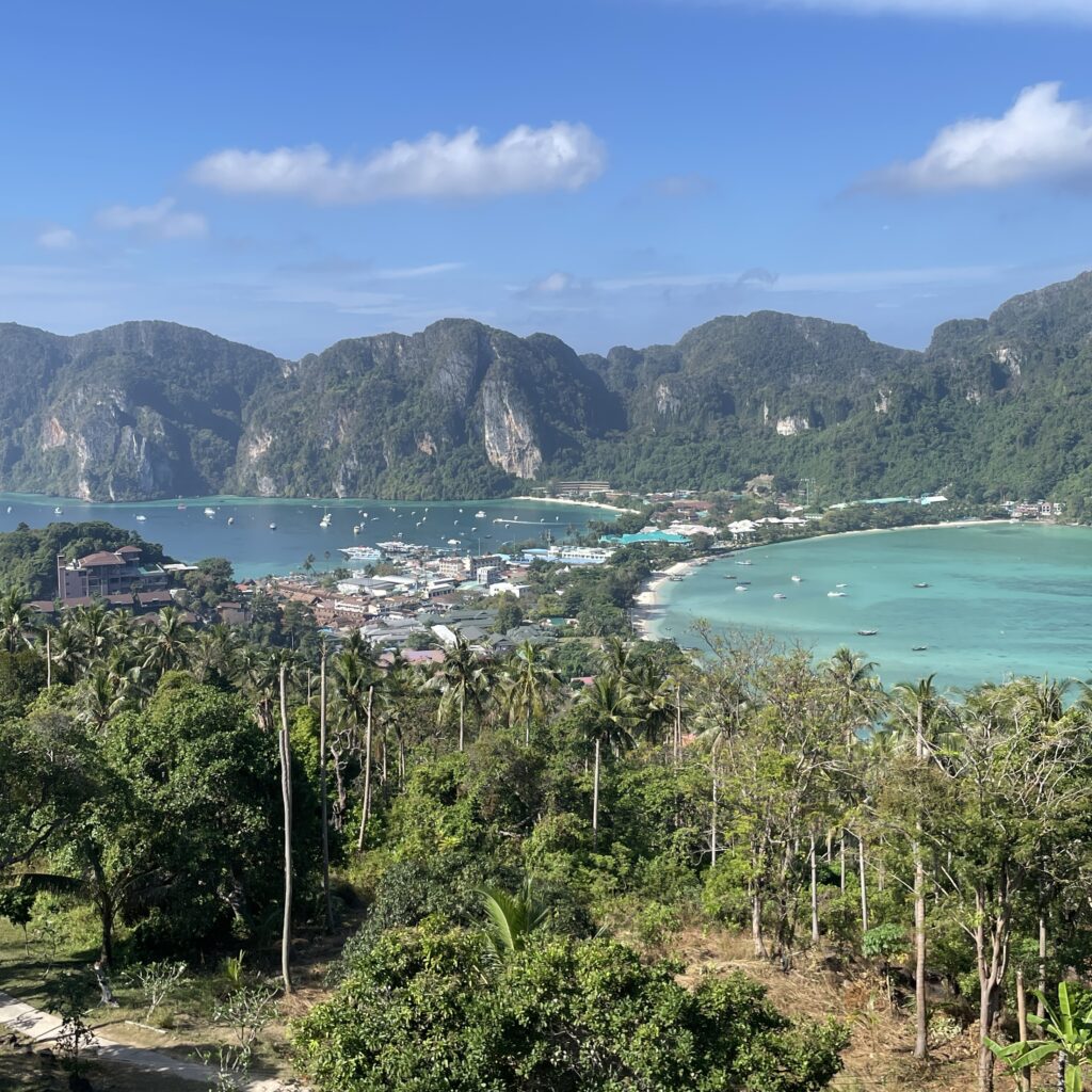 aerial views of the entire Koh Phi Phi Island showing clear skies, forest filled mountains and turquoise waters from each side of the island from Phi Phi Viewpoint 2