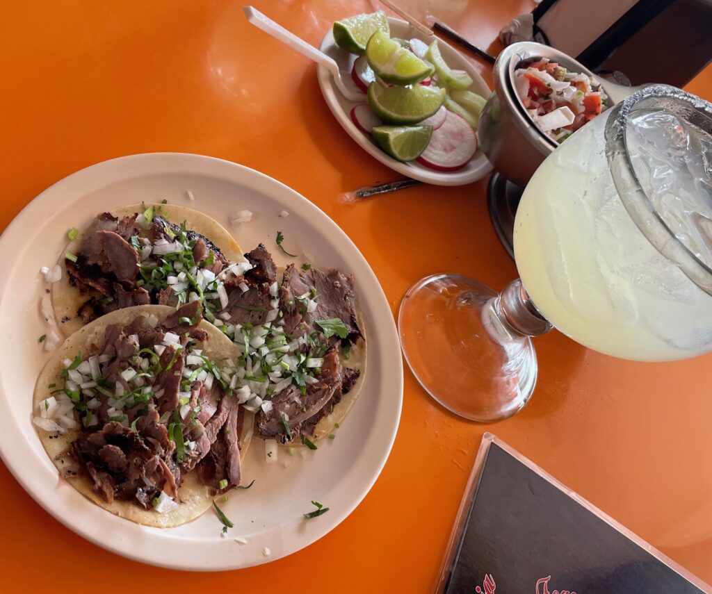 sirloin tacos topped off with cilantro, onions and sides of hot sauces on the side and a large margarita drink at El Fogon in Playa Del Carmen