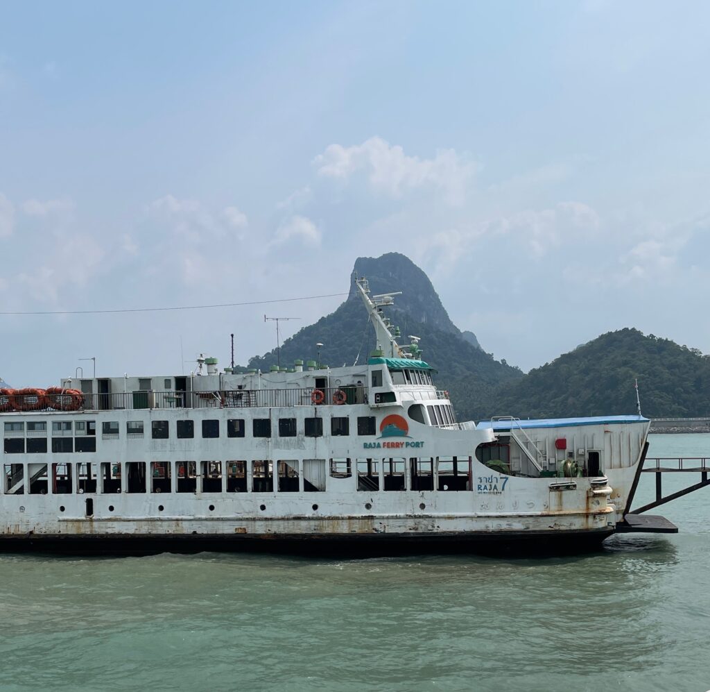 large ferry going from Surat Thani Pier to Koh Samui docked on the water with mountains in the background in Surat Thani. Thailand