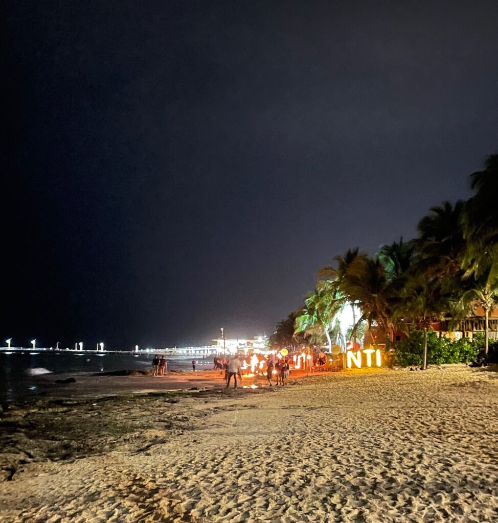 several lights at a beach clubs in the evening on Playa Del Carmen main beach at night