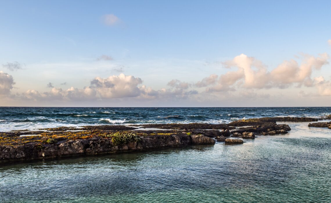 large rocks along a shoreline with clear skies just south of Puerto Aventuras / things to do in Puerto Aventuras