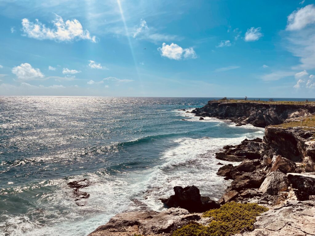 a beautiful coastline with large rocks elevated from the large waves at Punta Sur in Isla Mujeres, Mexico