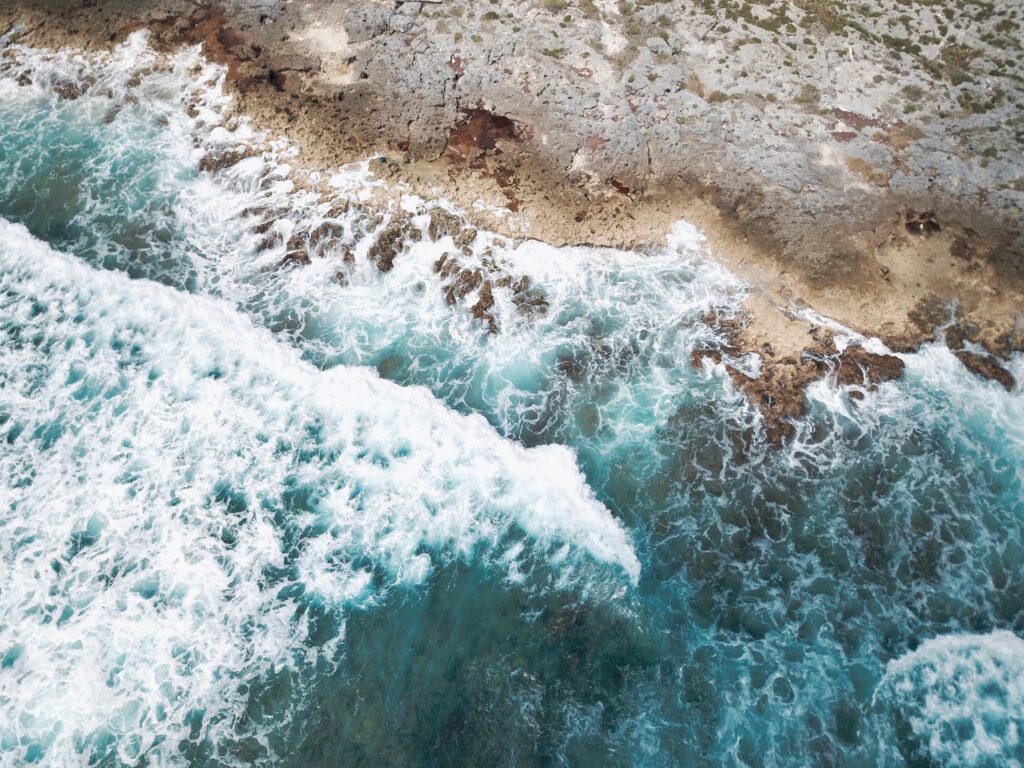 aerial photo of giant waves crashing into the shorelines of Akumal Beach in the Riviera Maya coastline of Mexico