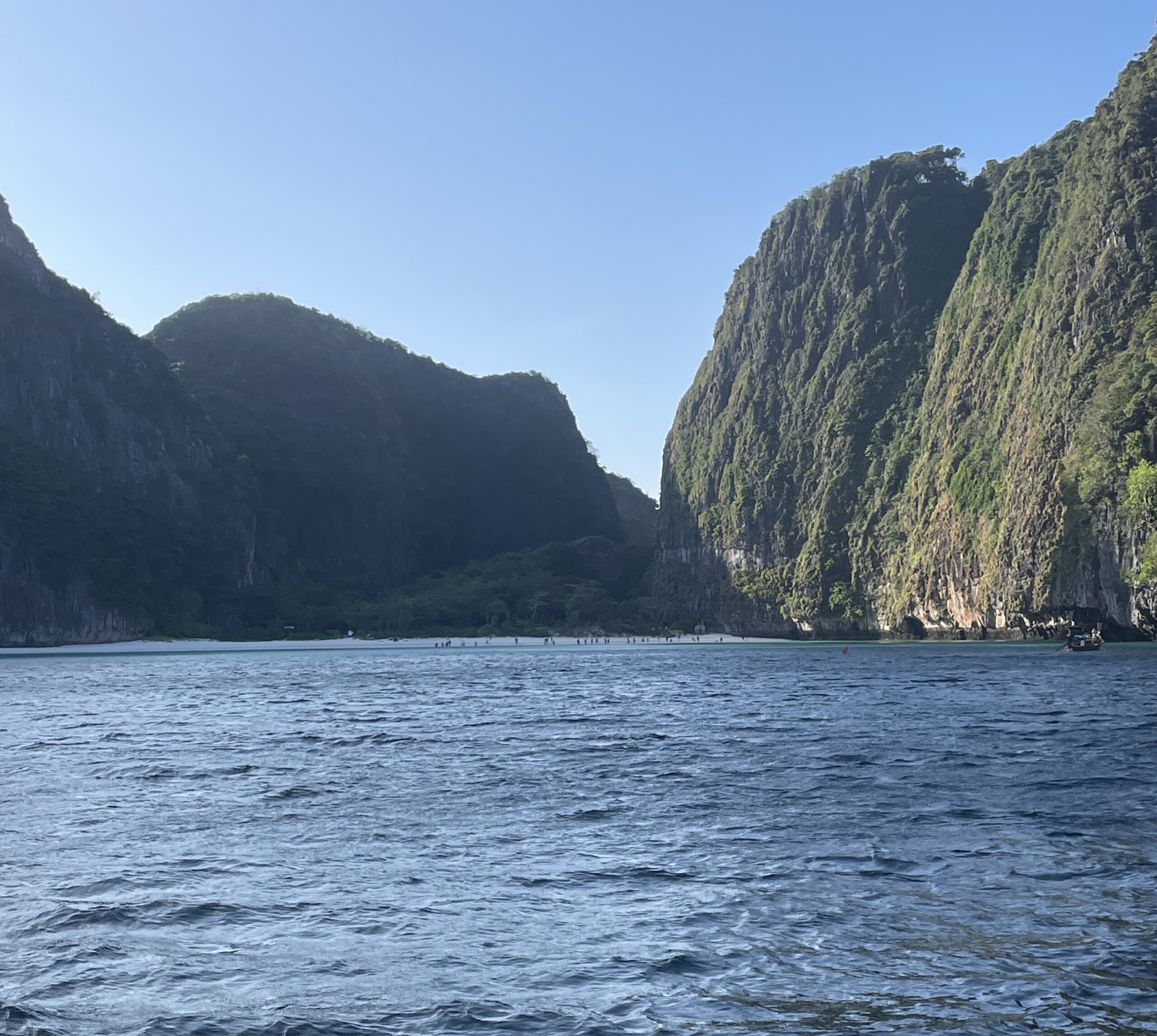 views of the famous Maya Bay Beach surrounded by large limestones from a longtail boat / how to get from Phuket to Maya Bay Beach