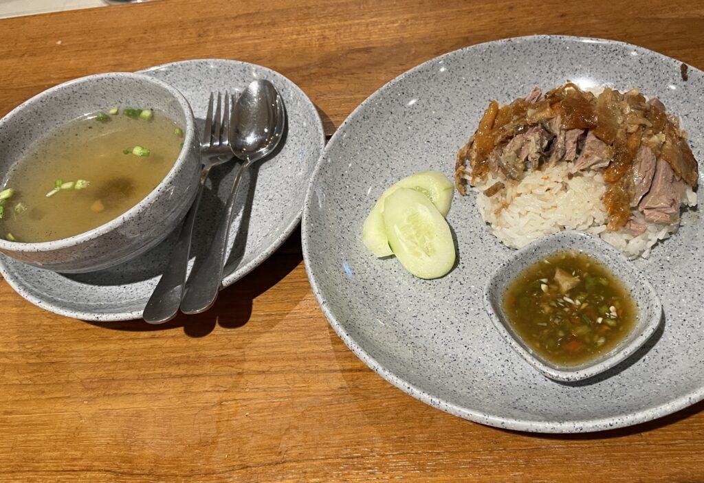 roasted duck on top of rice and cucumbers on the side with a side of rich duck broth from Metro Roasted Duck a Michelin star restaurant at Tops Food Hall in Patong, Phuket