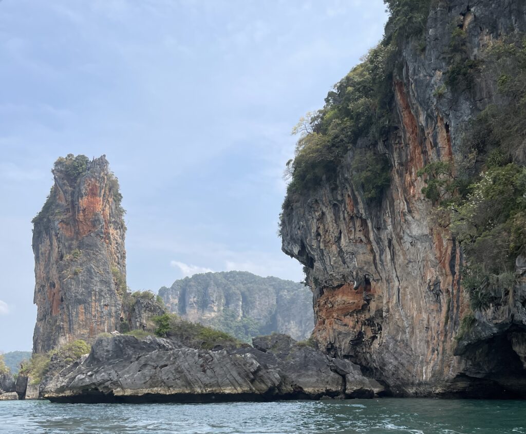 large limestones standing tall photographed from a long tail boat taxi between Ao Nang and Railay Beach 