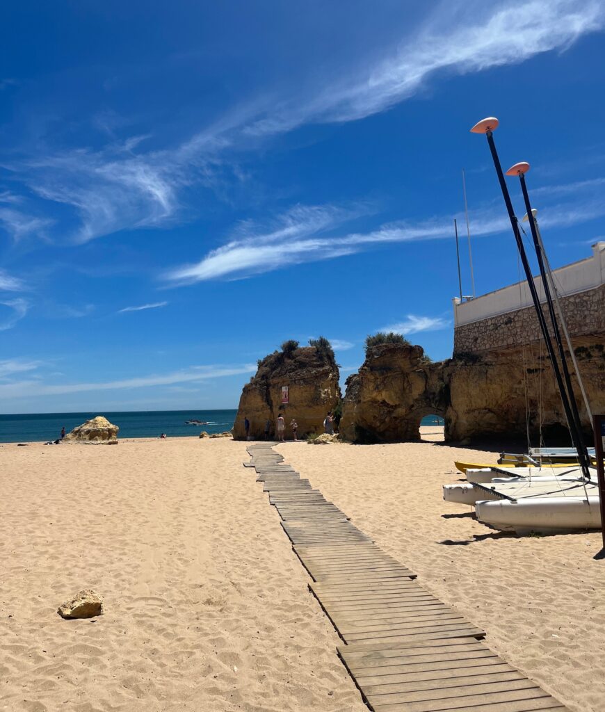 long path towards Batata beach on a clear skies day in Lagos, Portugal