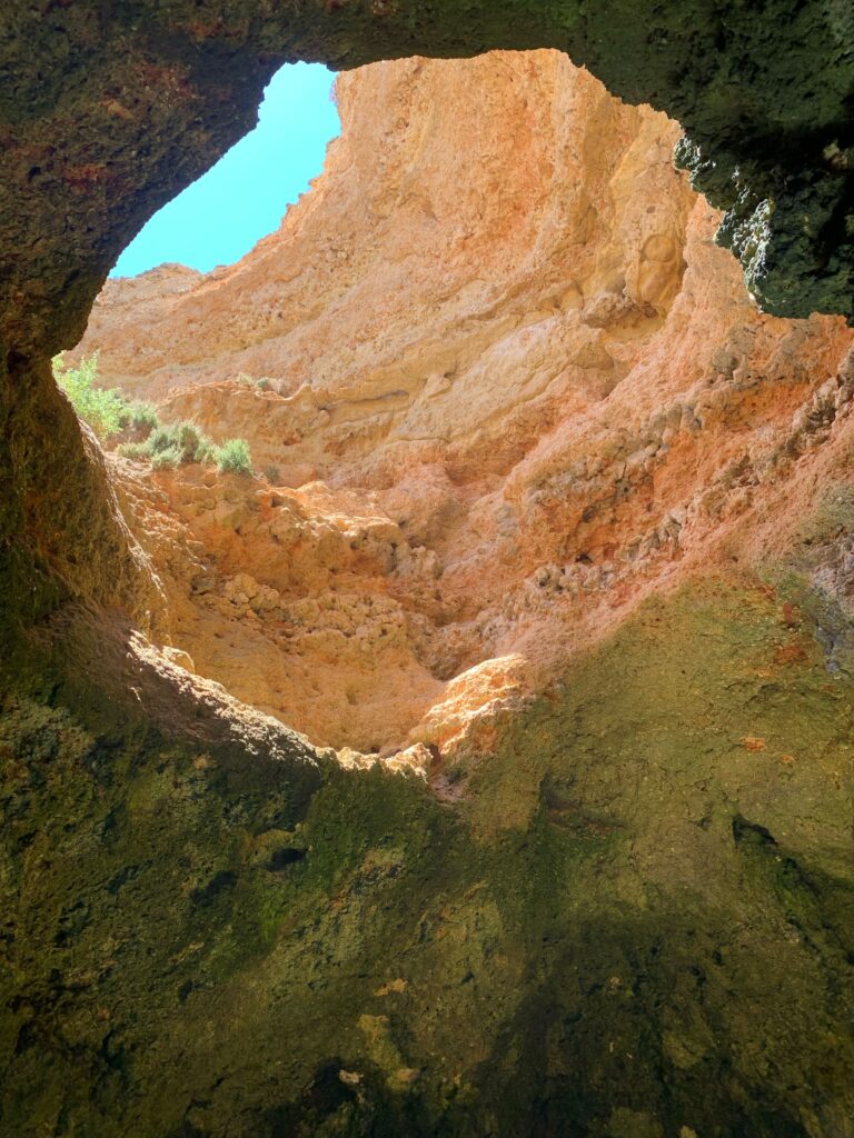 large hole within a rock formation at benagil caves in Lagos, Portugal