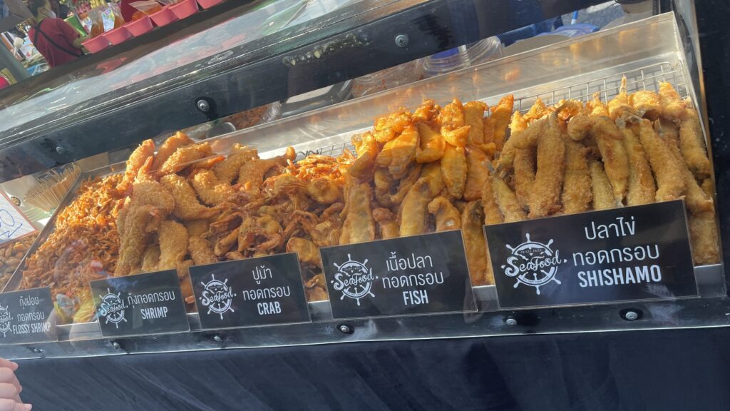 vendor stall showcasing various types of fried seafood being sold at the Sunday Market in Phuket