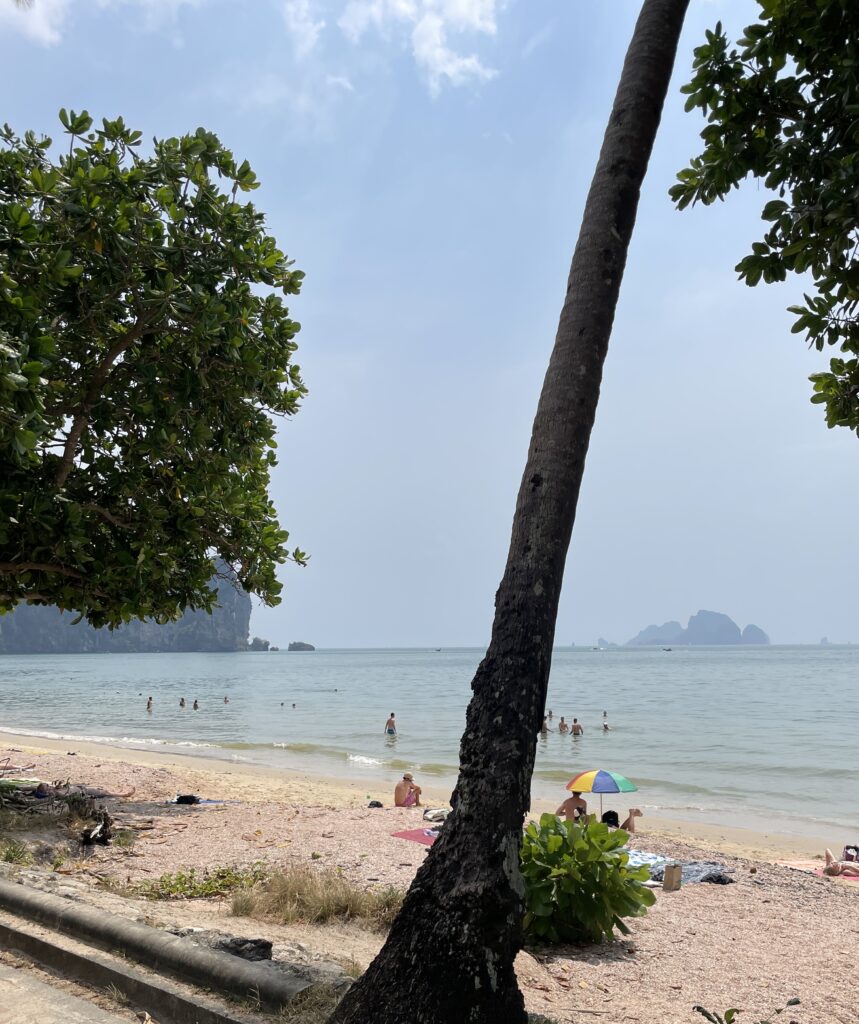 a few tourist relaxing along Ao Nang Beach in Krabi, Thailand