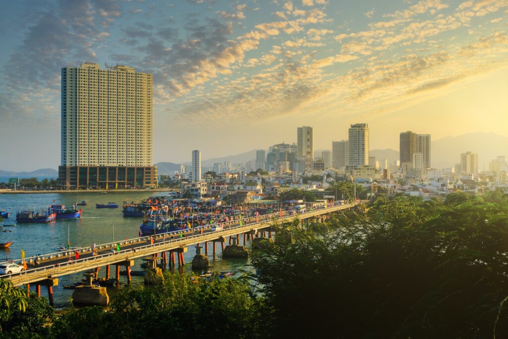 skyscraper buildings amongst a river and long bridge at sunset in Nha Trang, Vietnam 