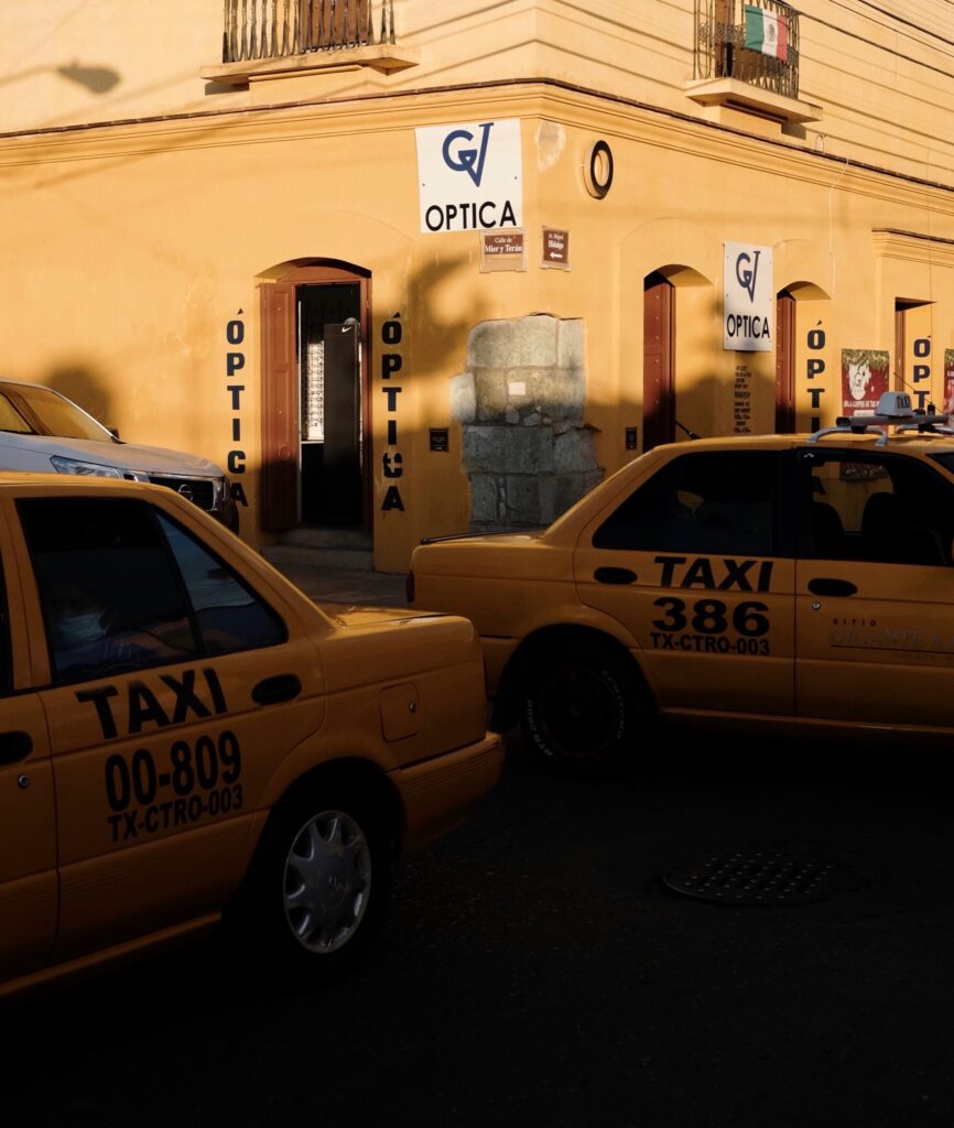 two taxis driving on the busy streets in Mexico