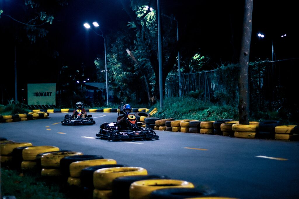 Two tourists go karting at night time 