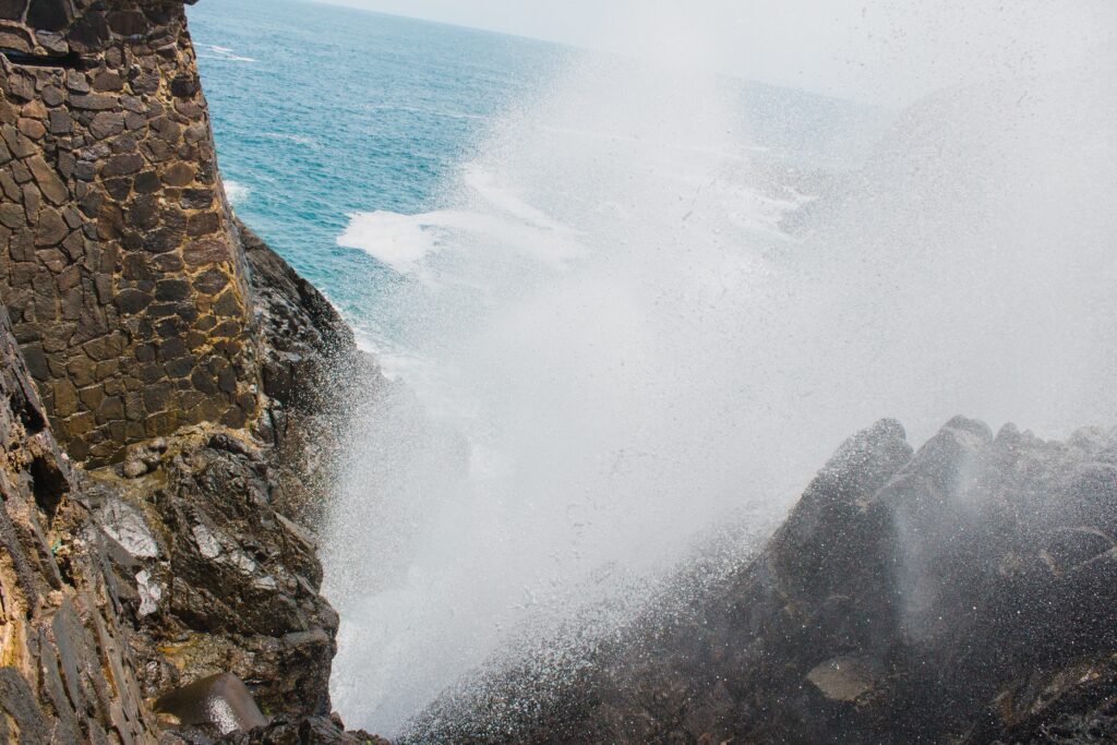 natural blowhole spewing water high up into the air at La Bufadora in Ensenada, Mexico