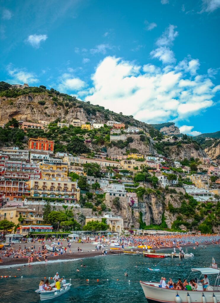 several tourist on a crowded beach on a sunny day in Positano, Italy 