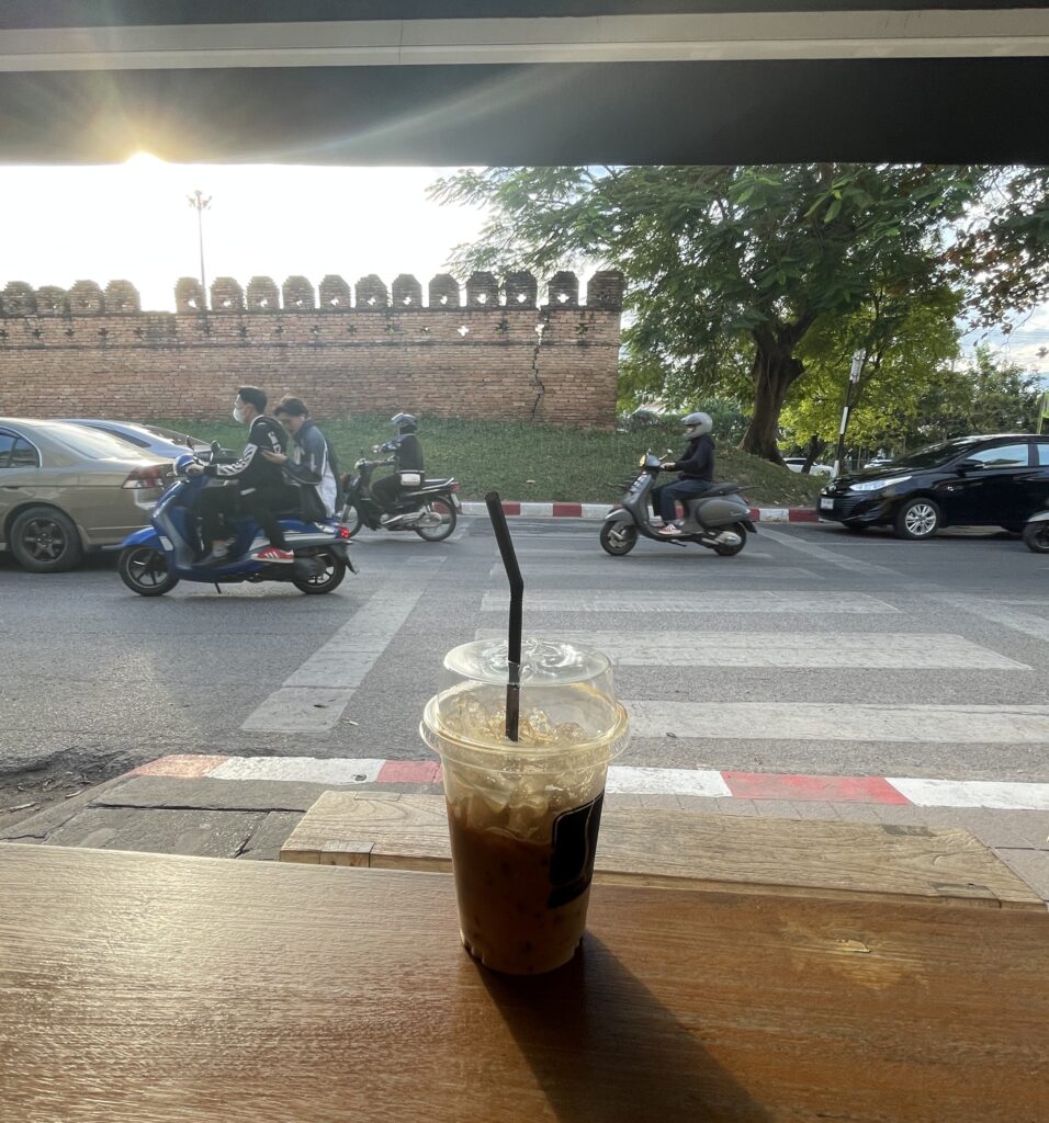 scooters and cars driving by near the ancient old City walls in Chiang Mai, Thailand