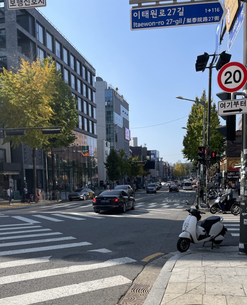 a park scooter and cars driving buy in the charming contemporary district of Itaewon in Seoul, Korea