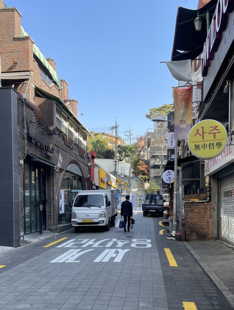 a gentlemen in his suit walking down a picturesque street in Seoul, Korea