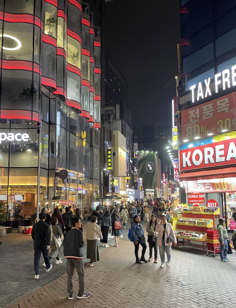 crowded intersection in Myeongdong full of locals and tourists visiting the local night market
