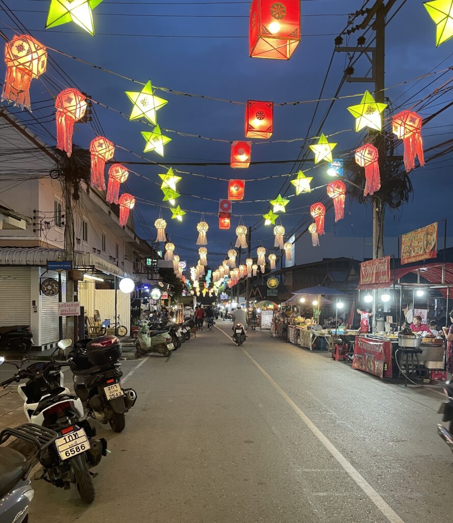 food vendors, lantern lights during the start of a lively night in Pai, Thailand 