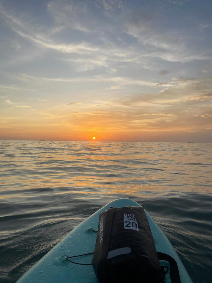views of a vibrant sunset along the water from a paddle board in Koh Lanta, Thailand