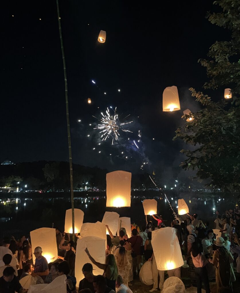 several locals and tourists releasing lanterns into the sky at Doi Saket for the Yi Peng