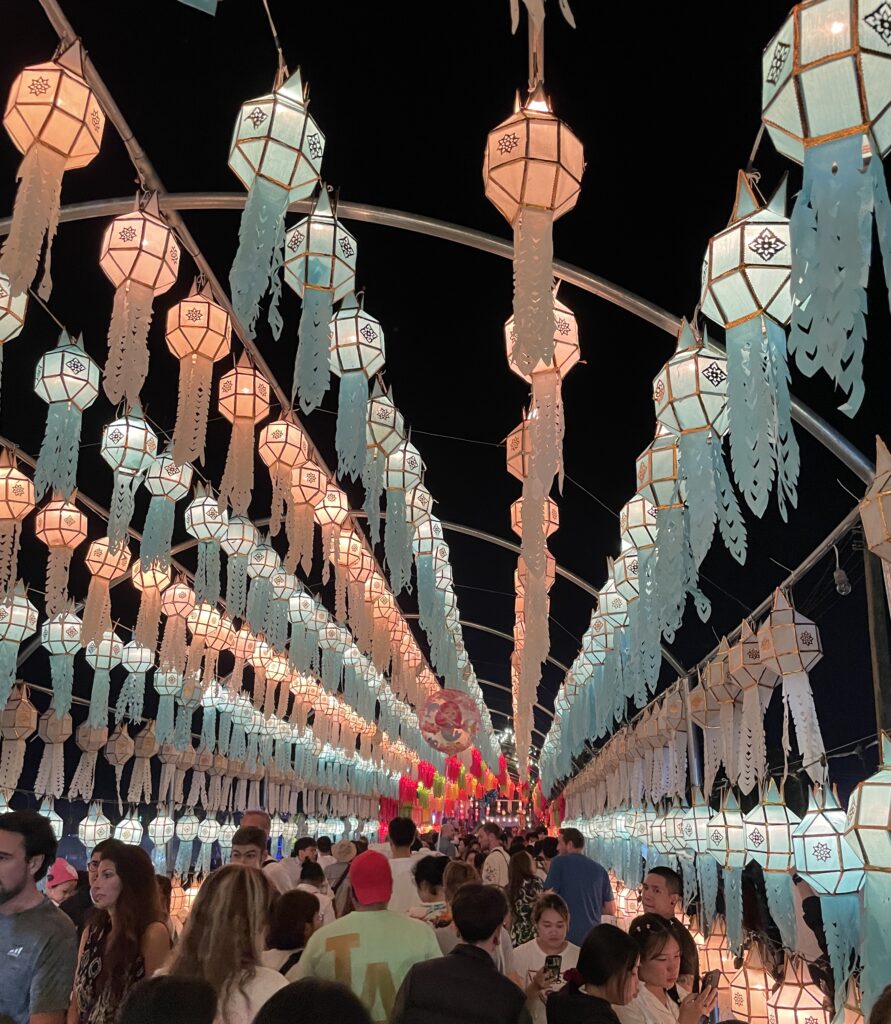 many locals and tourist walking past a bridge full of decorations at Doi Saket during Lantern Festival