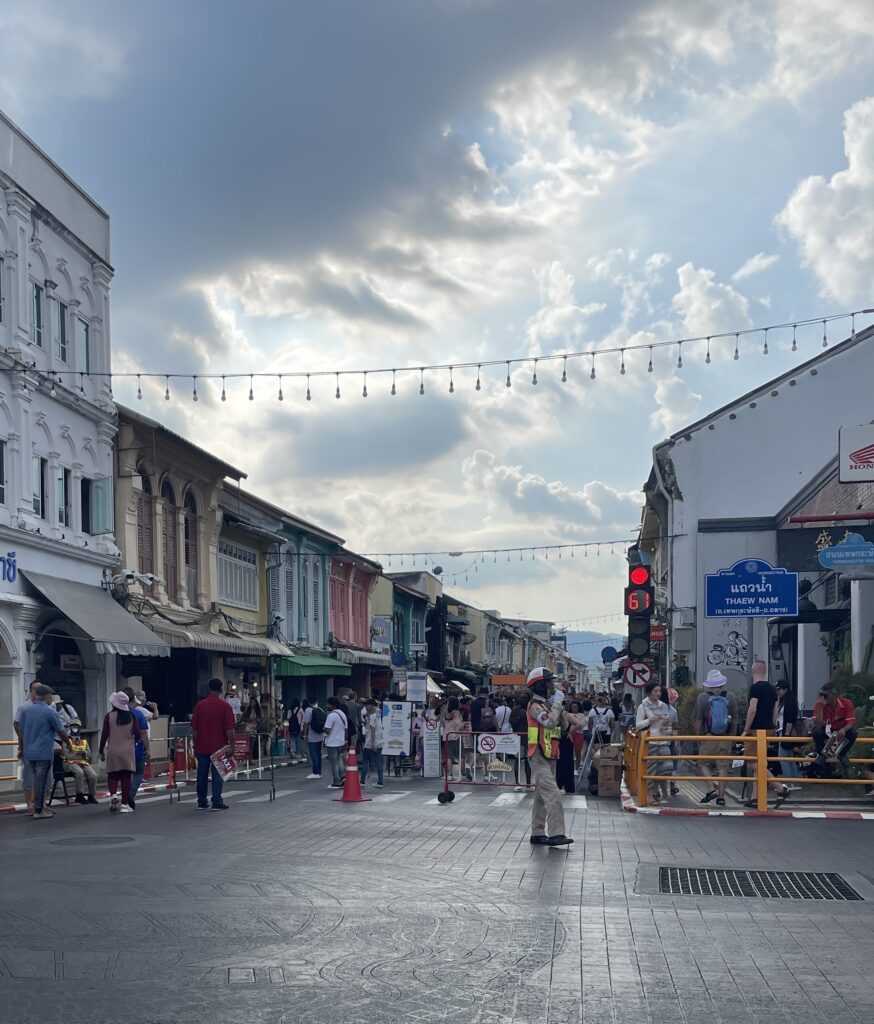 Thai police officer directing traffic in Old Phuket Town. on a sunny day