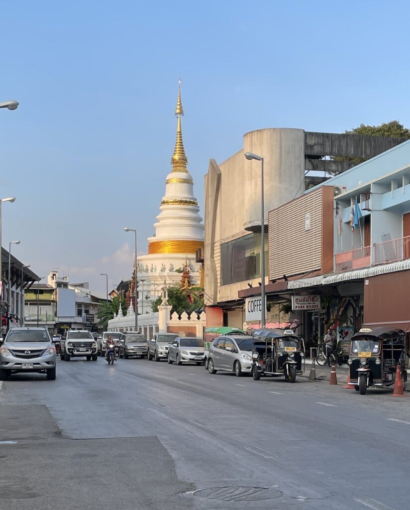 clear road with a beautiful temple in the distance during the evening in Chiang Mai, Thailand 