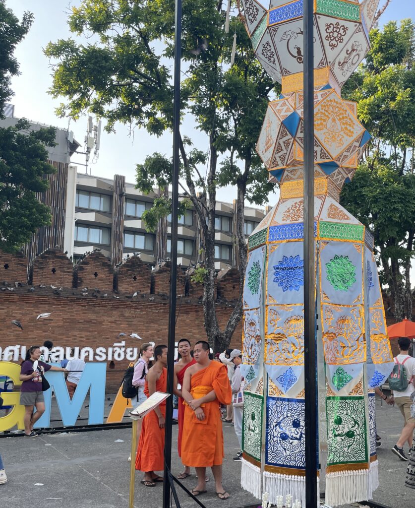 monks standing beside elaborate lantern decorations in Chiang Mai