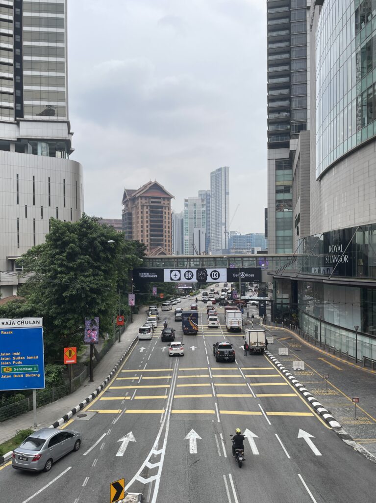 view traffic in Kuala Lumpur from a bridge on a clear sky day 