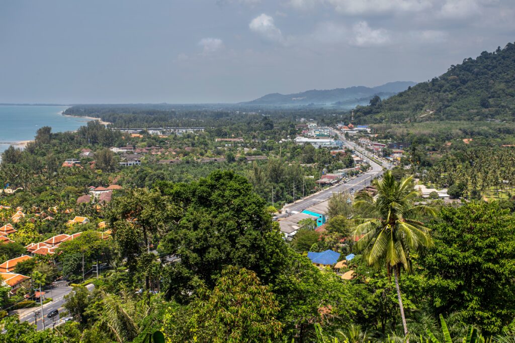 Aerial view of Khao Lak's main road with beaches, mountains and greenery in the distance