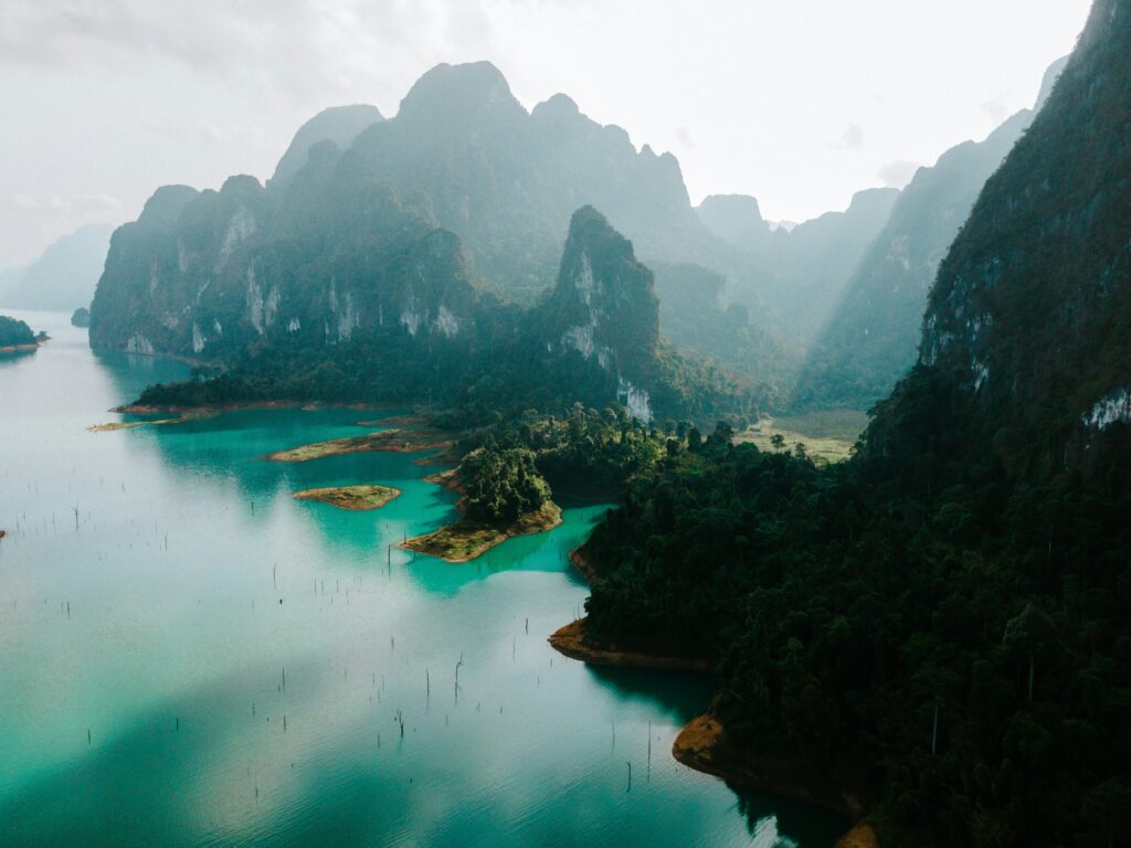 aerial shot of the many large limestones and lush greenery around the lake at Khao Sok National Park in Thailand 