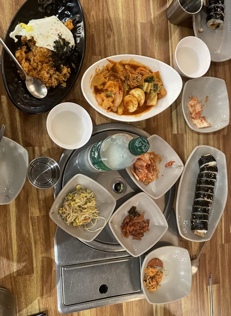 several Korean dishes spread out on a table along with Korean drinks in Myeongdong, Seoul, South Korea
