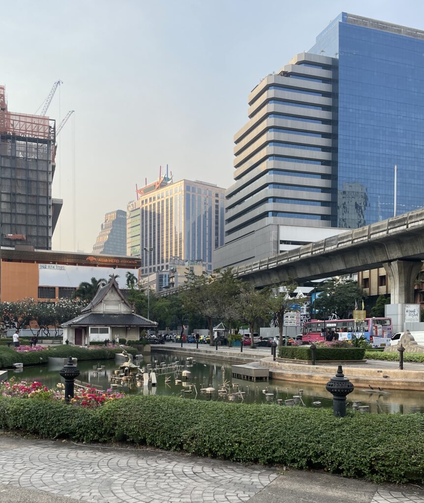greenery with buildings in the distance at Bencharsiri Park in Bangkok, Thailand