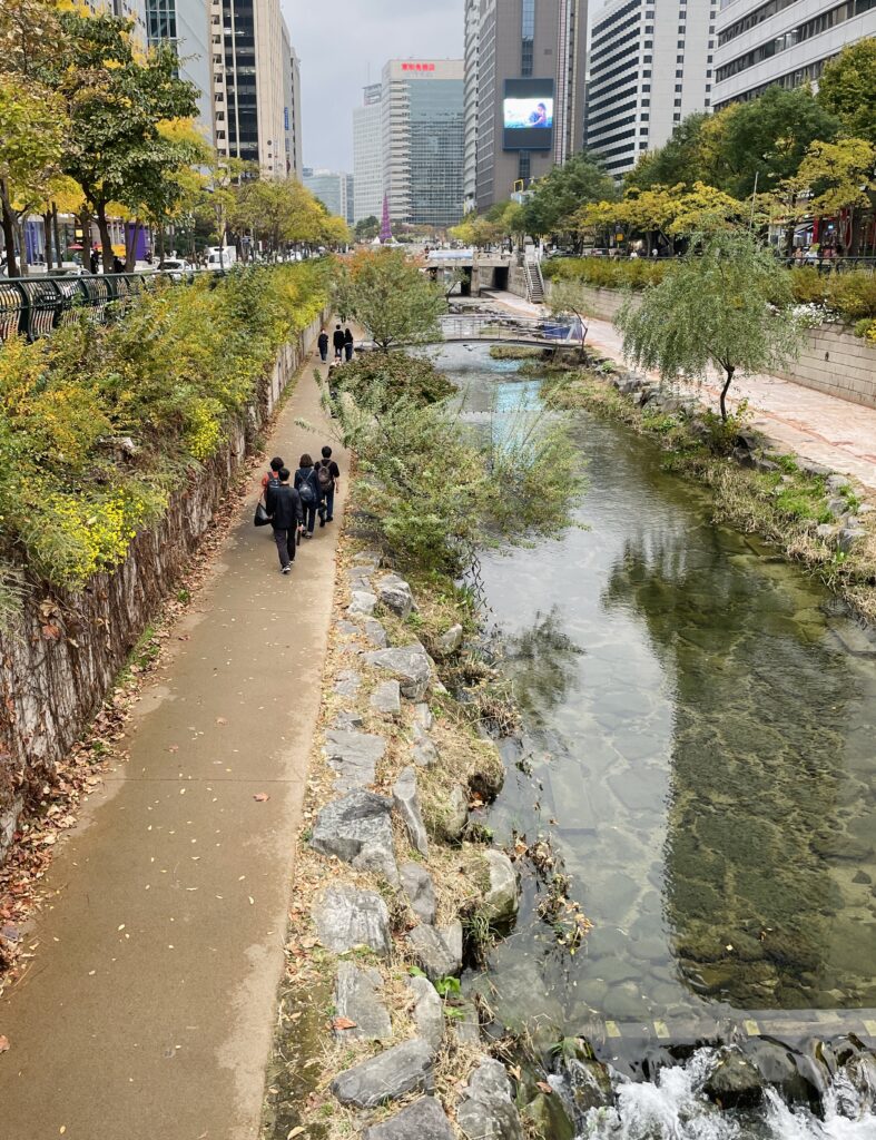 locals walking along the stream and greenery at Cheonggyecheon Park in Seoul 