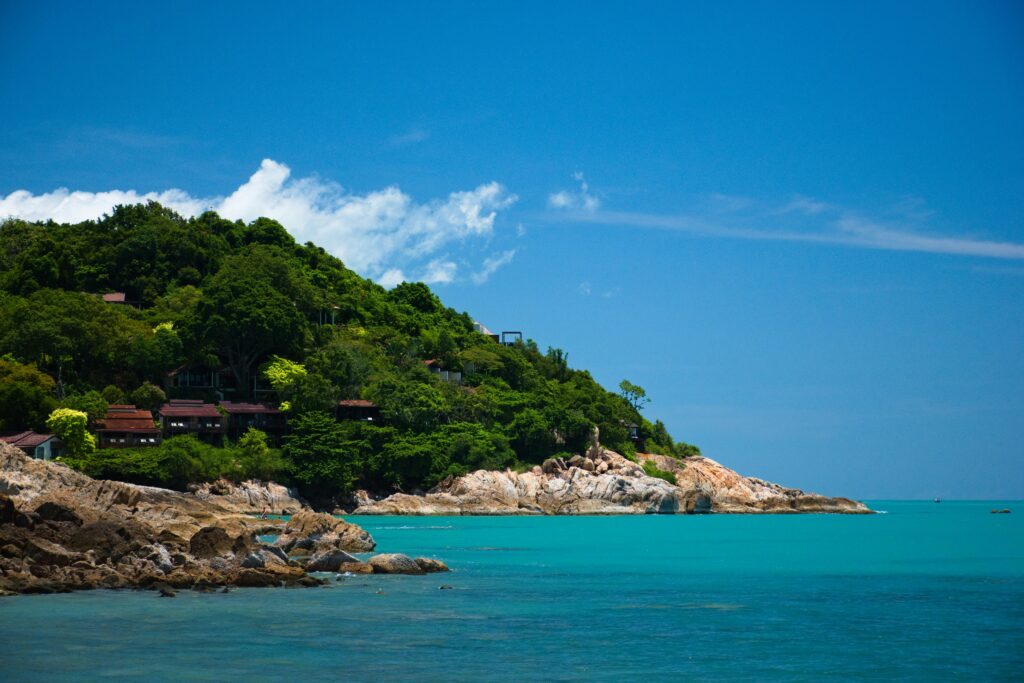 many rocks and trees along the turquoise waters in Koh Samui on a beautiful day 