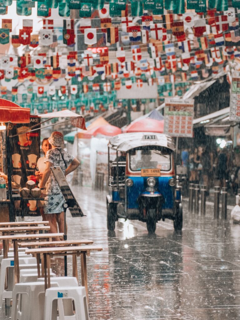 a tuktuk driving along the streets in Bangkok on a day when it's pouring rain in the off season 