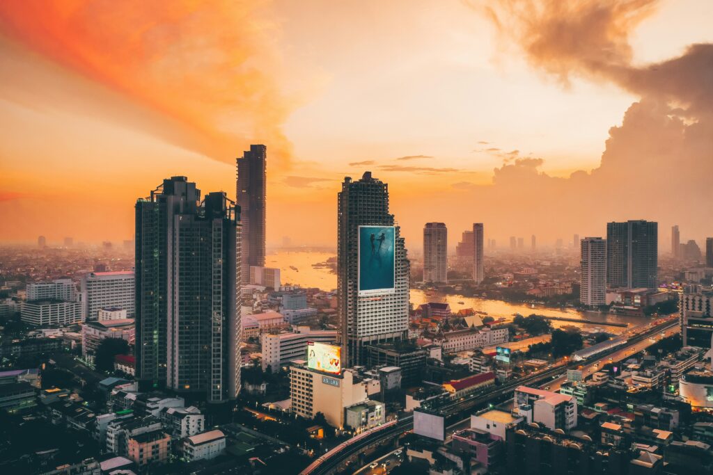 a vibrant orange sky amongst several skyscrapers in Bangkok, Thailand 